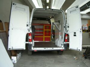 Furgone attrezzato per soccorso stradale con verricello, rampe di carico, segnaletica di emergenza e luci lampeggianti, pronto per interventi su strada